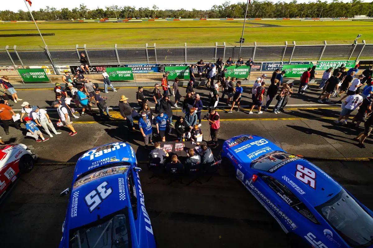 Fans gather around the GT4 cars during the pit walk at Queensland Raceway