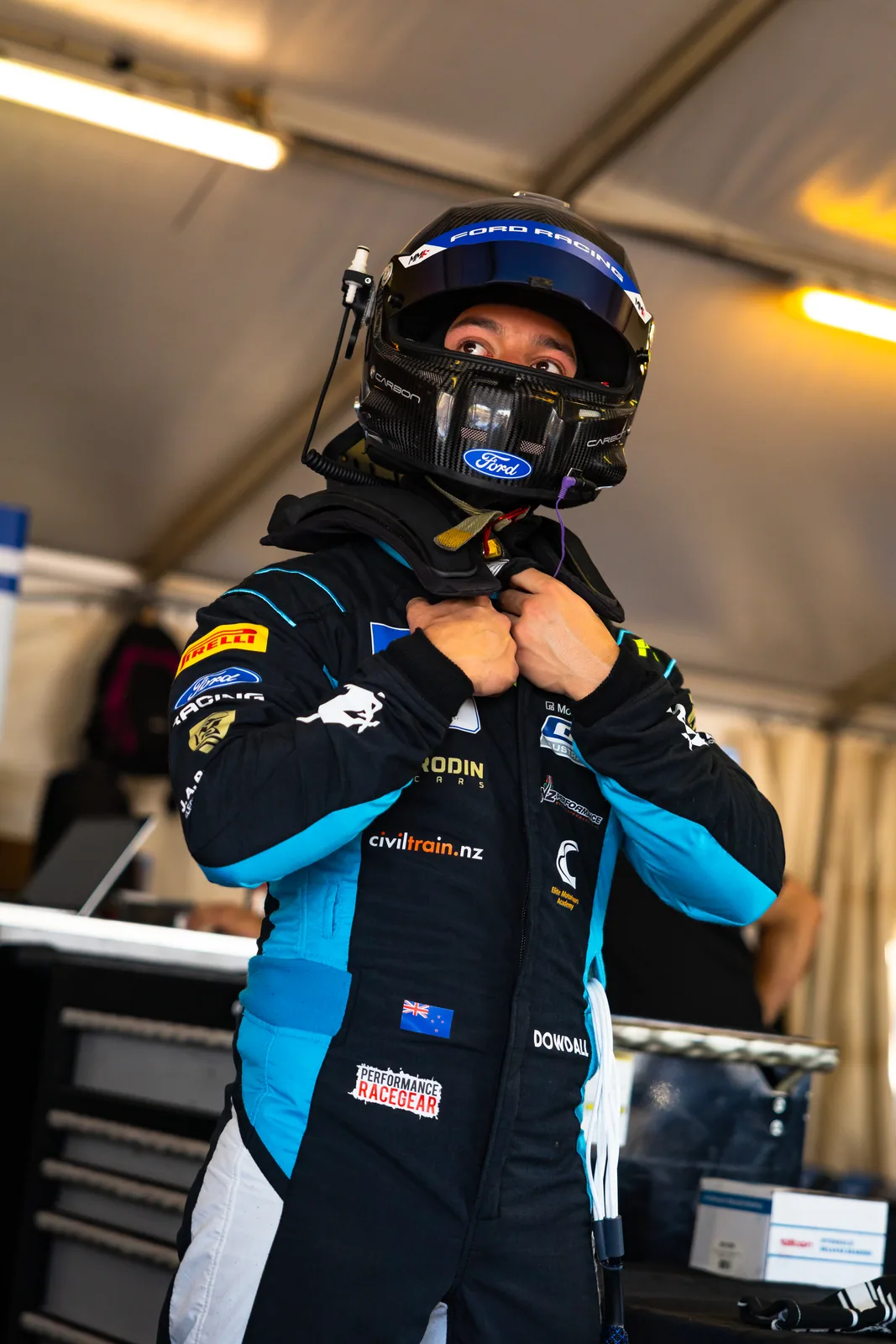 Blake Dowdall in his race suit and helmet in the garage at Hidden Valley