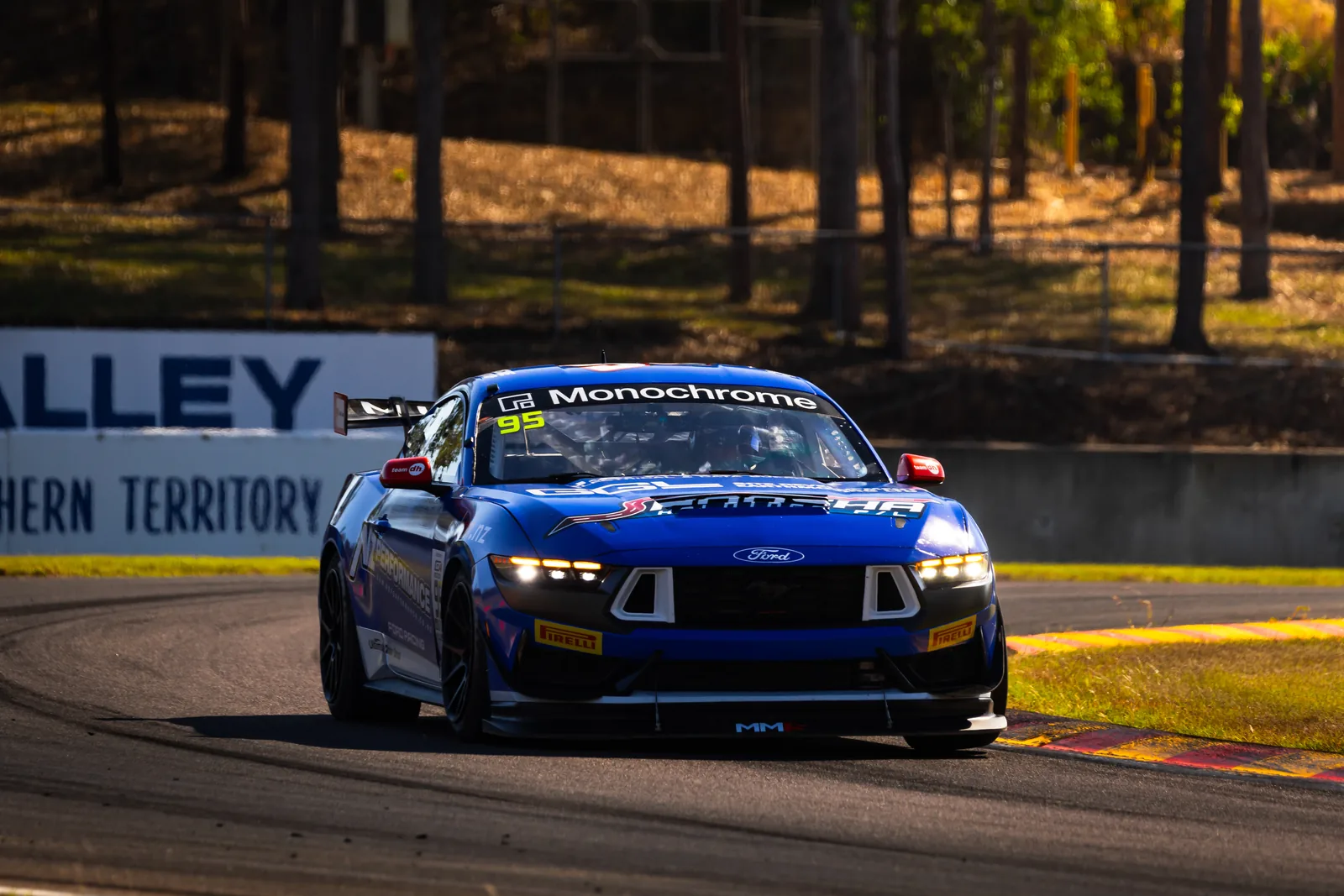The #95 Ford Mustang GT4 on track past the Hidden Valley signage in Darwin