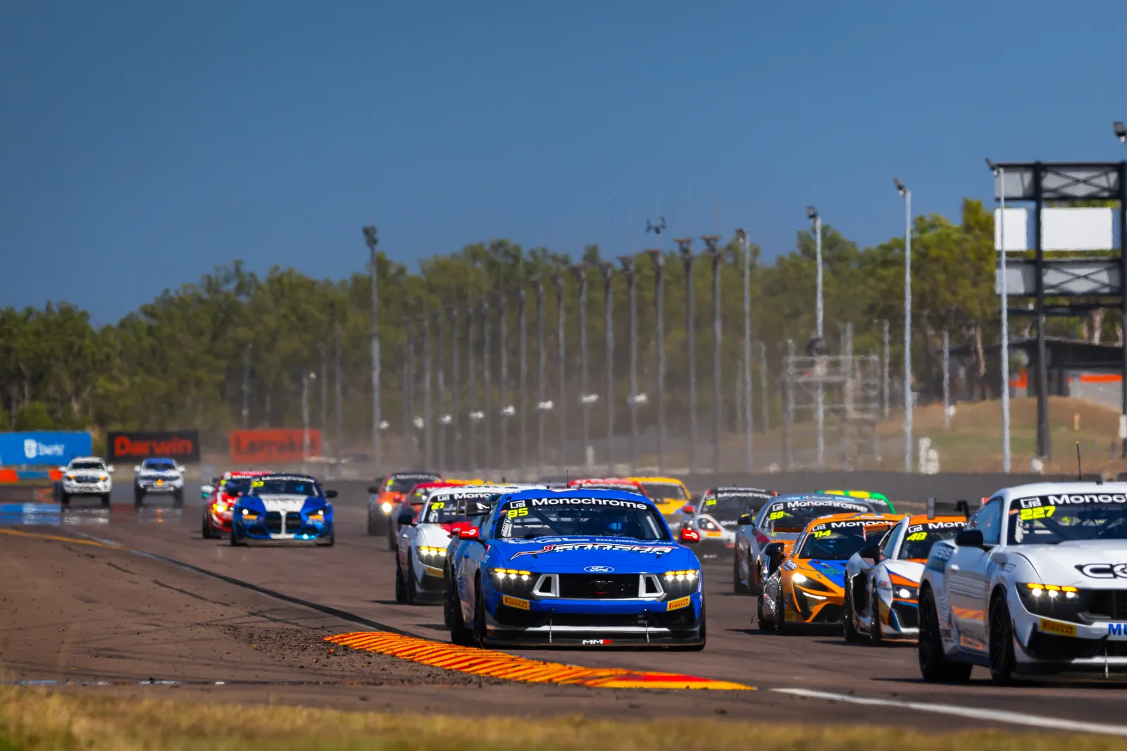 The GT4 Australia field streams into Turn 1 at the start at Hidden Valley