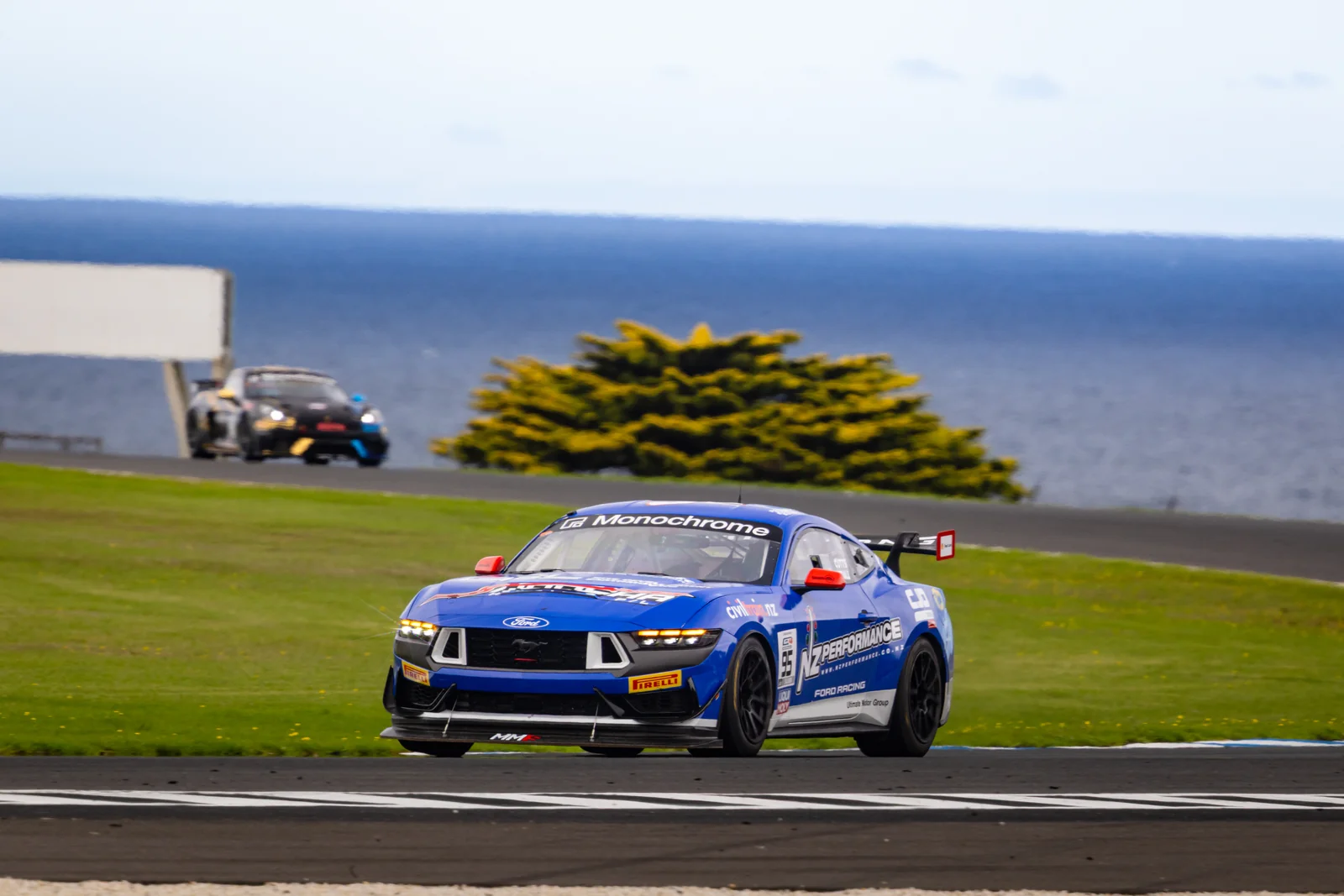 Blake Dowdall's Ford Mustang GT4 on track above the Phillip Island coastline