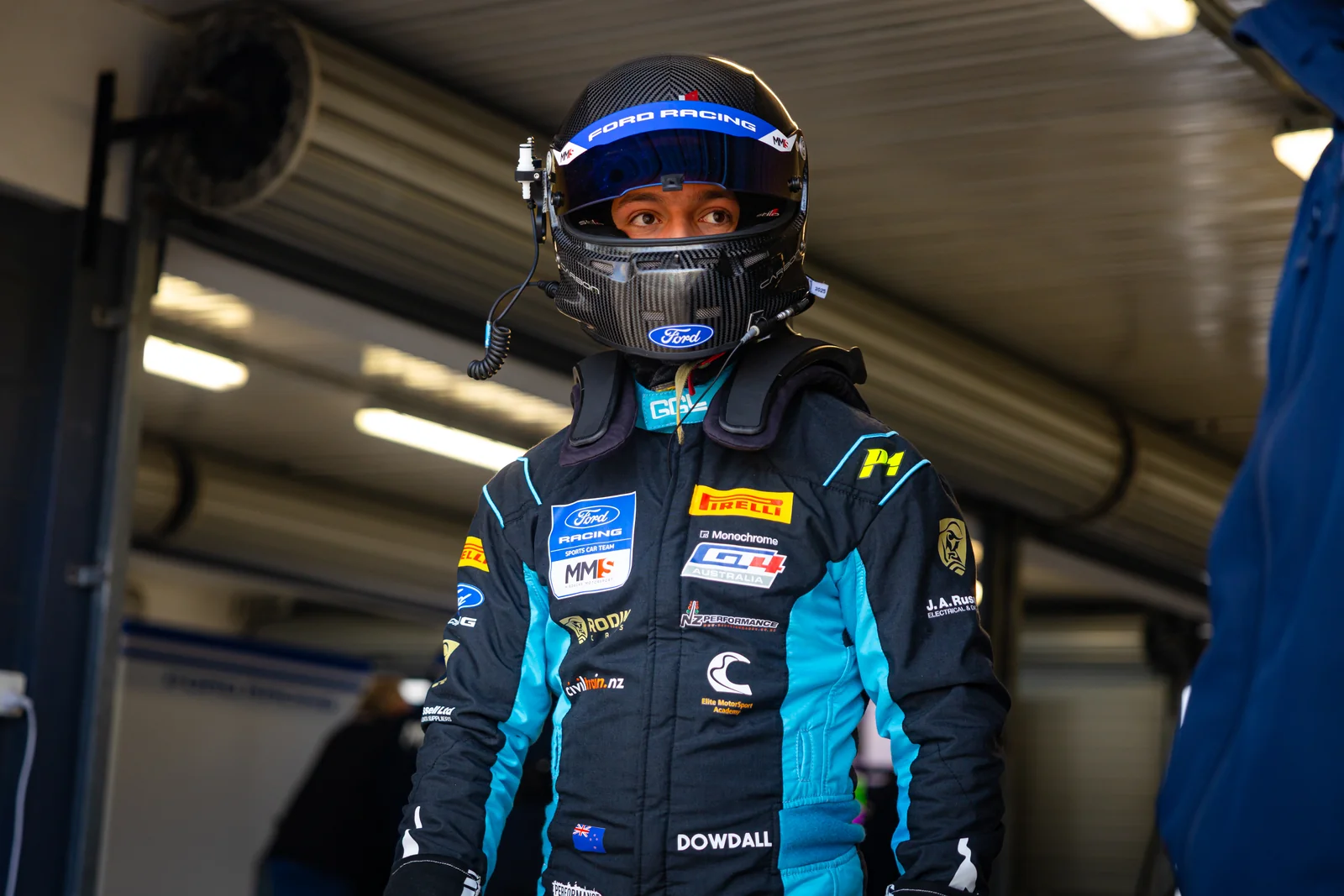 Blake Dowdall in race gear beside his Ford Mustang GT4 at Phillip Island Round 1