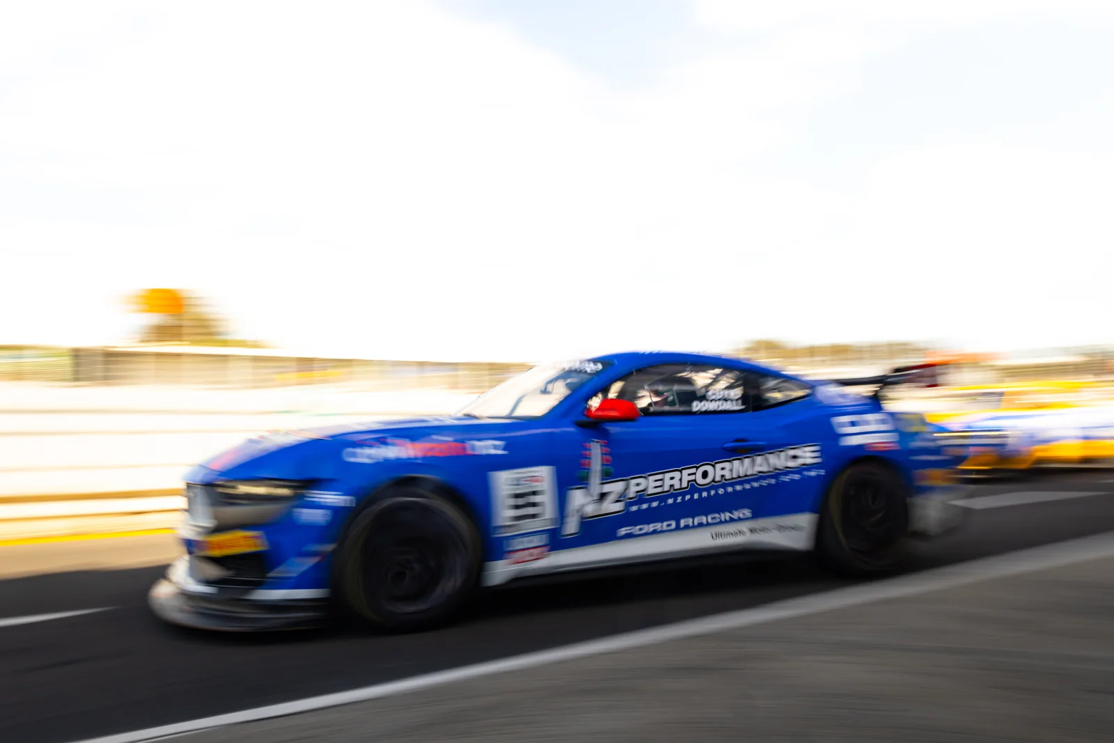 Blake Dowdall's #95 Ford Mustang GT4 at speed into the sun at Phillip Island