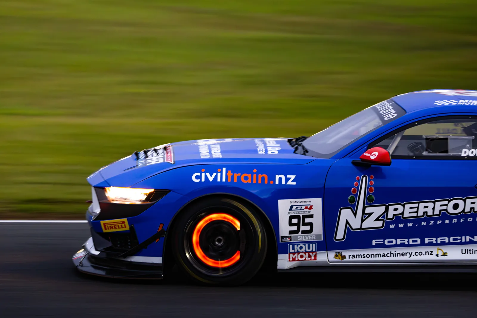 The #95 Ford Mustang GT4 at speed under lights in the Queensland Raceway night race