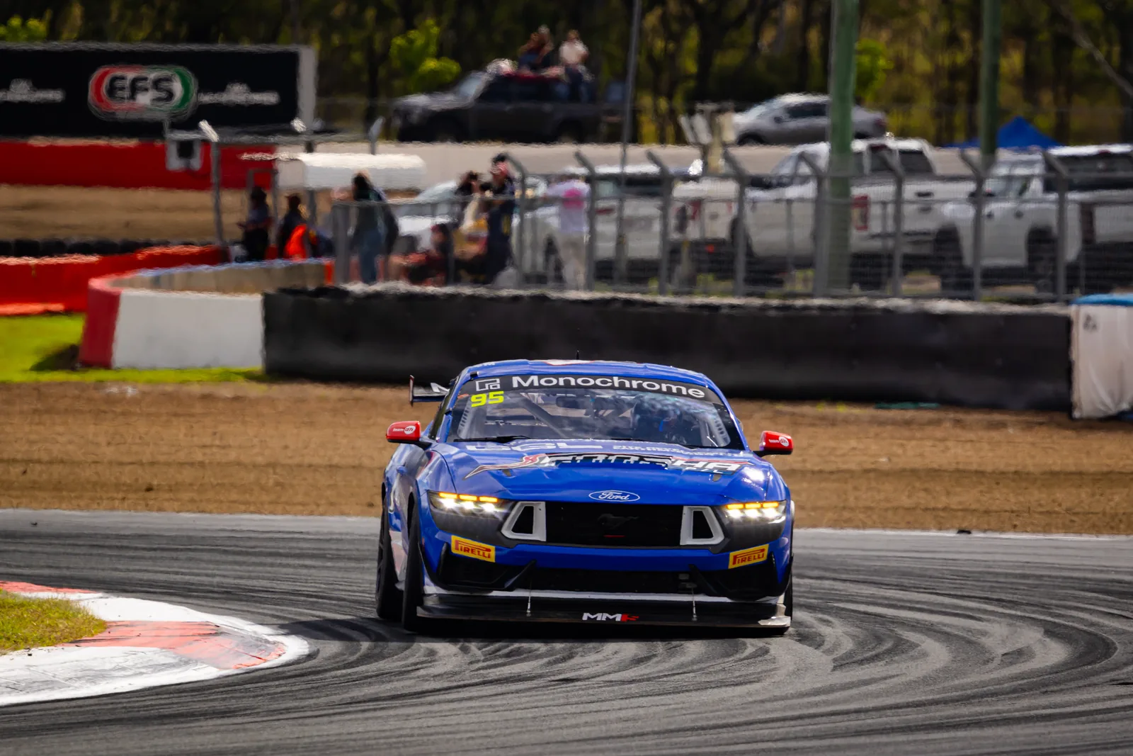The #95 Ford Mustang GT4 attacks the kerbs during Race 2 at Queensland Raceway