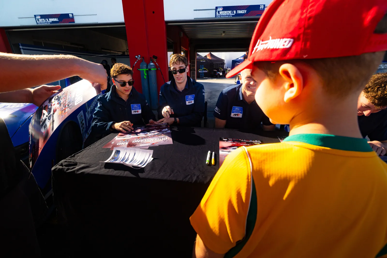 Blake Dowdall signs a poster for a young fan at Queensland Raceway