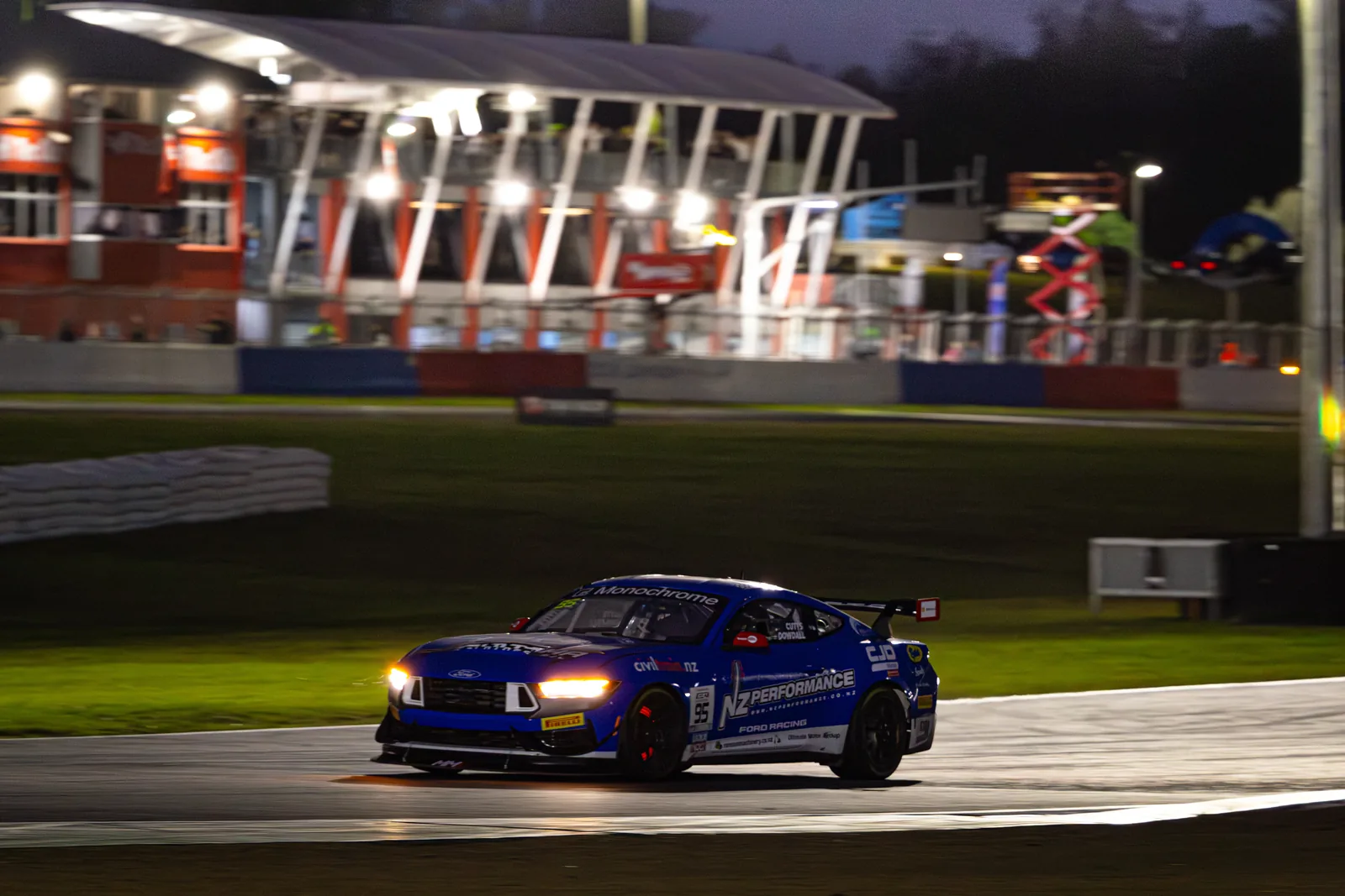 Blake Dowdall's Mustang GT4 passes the grandstand under lights at Queensland Raceway