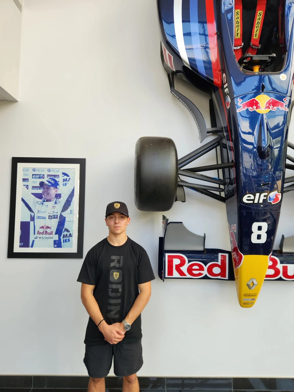 Blake Dowdall alongside a Formula 1 show car during his European trip